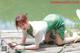 A woman in a green dress laying on a wooden dock.