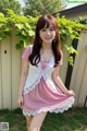 A woman in a pink and white dress posing for a picture.