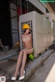 A woman in a yellow hard hat sitting on a chair.