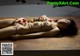 A naked woman laying on a wooden table covered in sushi.