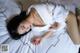 A woman laying on a bed in a white robe.