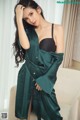 A woman in a green robe is posing for a picture.