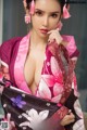 A woman in a pink kimono posing for a picture.